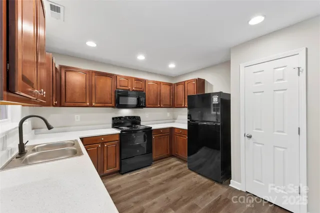 a kitchen with stainless steel appliances granite countertop a refrigerator stove and sink
