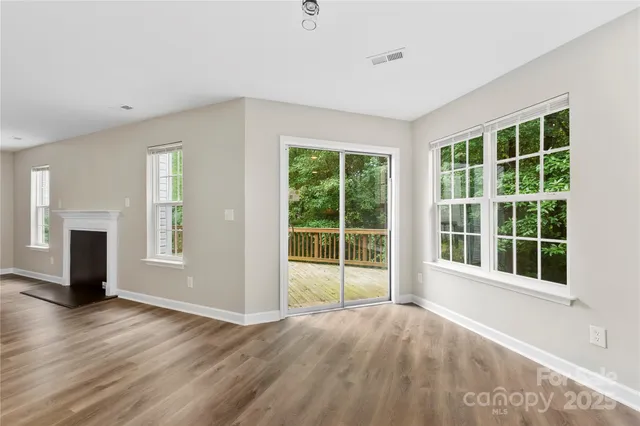 a view of empty room with wooden floor and fireplace