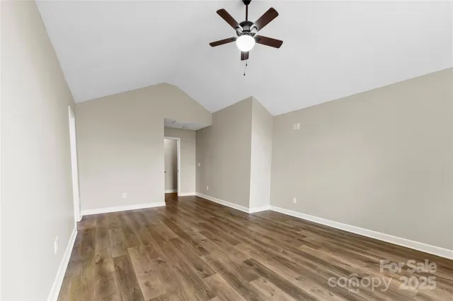 a view of a big room with wooden floor and a ceiling fan