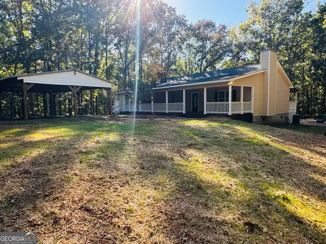 a backyard of a house with barbeque oven table and chairs