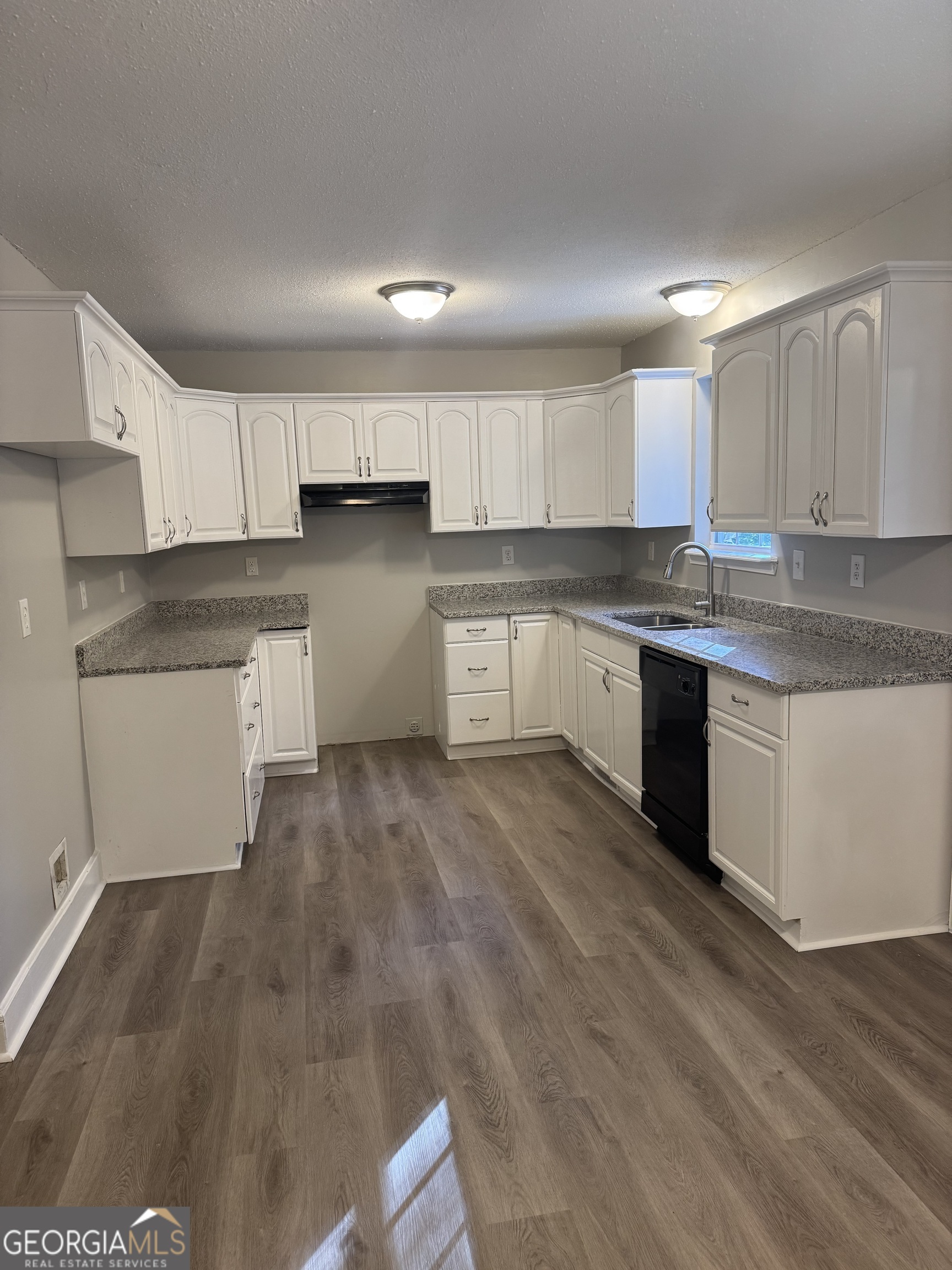 1516 Stark Road Jackson, GA 30233 - Photo 25 of 37 a kitchen with granite countertop a stove top oven a sink and cabinets