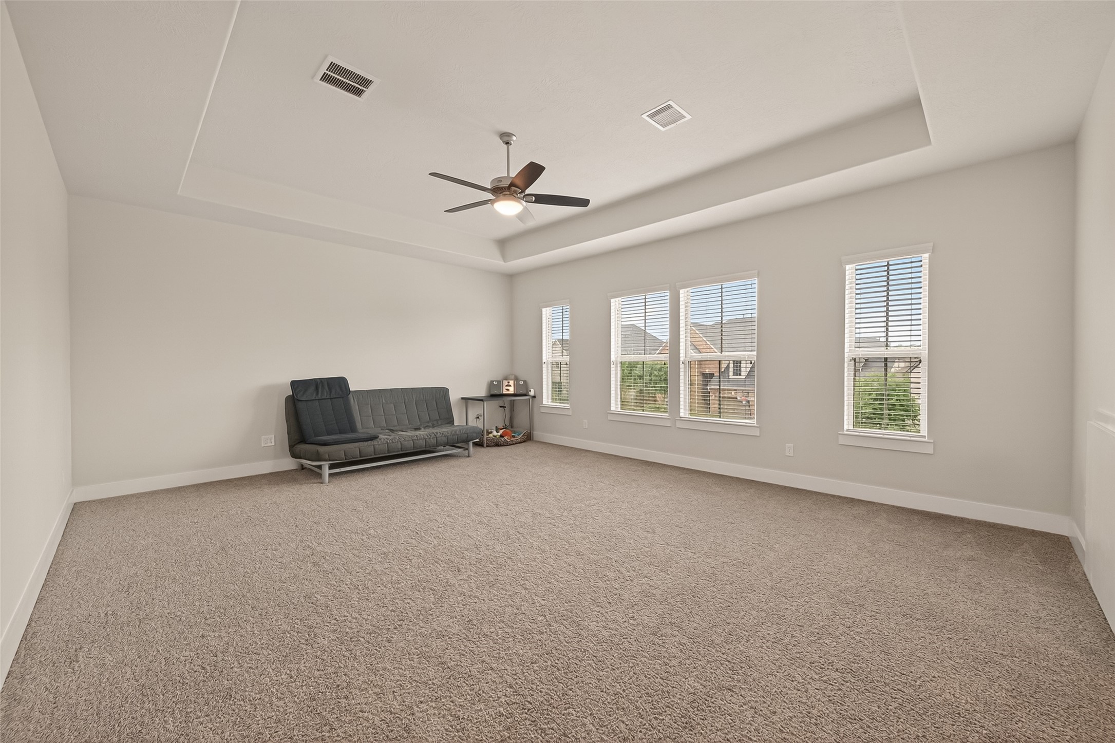 1815 Brea Rdg Trail Katy, TX 77494 - Photo 30 of 43 This spacious, carpeted game room features a modern ceiling fan, tray ceiling, and ample natural light from three large windows.