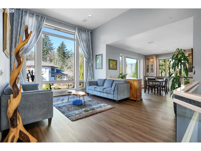 a living room with furniture large window and wooden floor