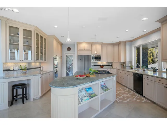 a kitchen with stainless steel appliances granite countertop a stove refrigerator sink and cabinets
