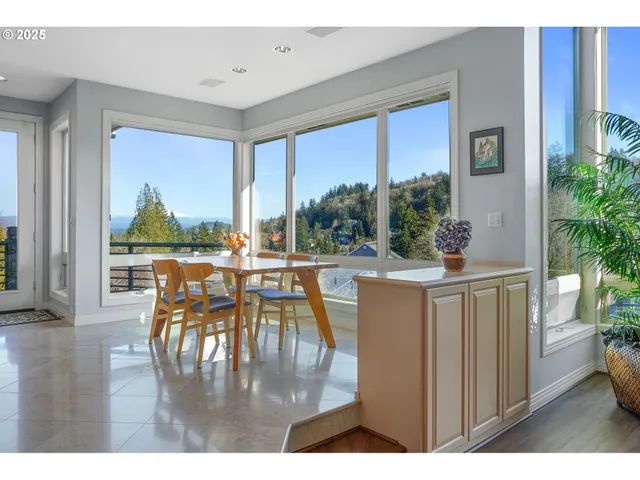 a living room with large windows and a table