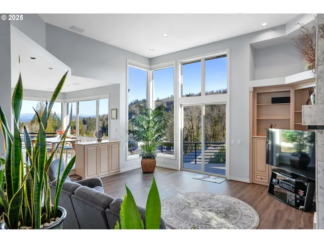 a living room with furniture a flat screen tv and a floor to ceiling window