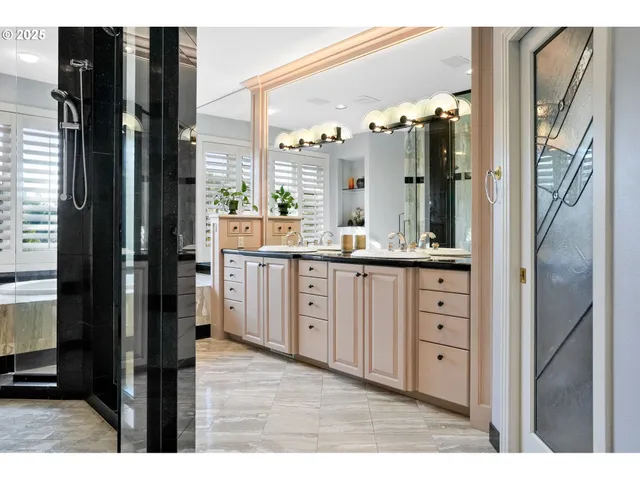 a bathroom with a double vanity sink a mirror and a shower