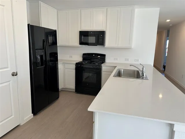 a kitchen with a refrigerator and a stove top oven
