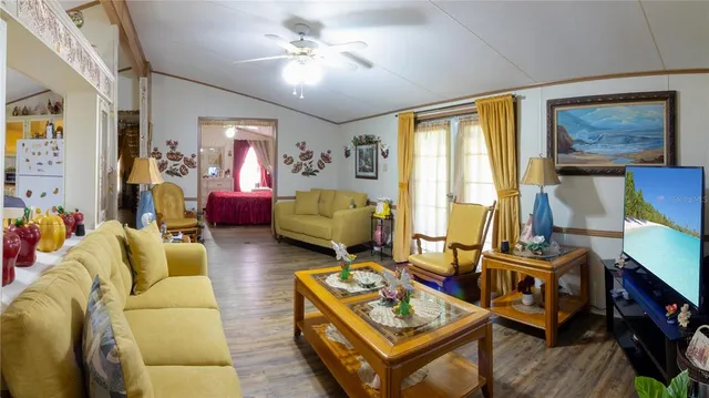 a living room with furniture a flat screen tv and a window