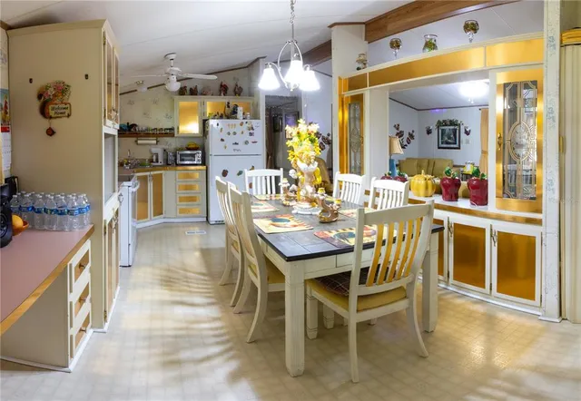 a kitchen with stainless steel appliances kitchen island granite countertop dining table chairs and a large window