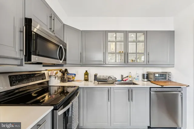 a kitchen with stainless steel appliances a stove sink microwave and cabinets