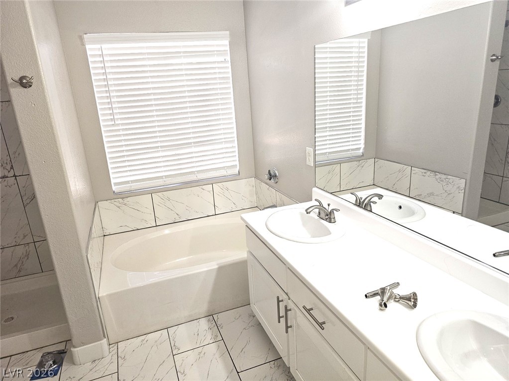 1418 Reebok Terrace Henderson, NV 89014 - Photo 26 of 38 Dual vanities and a deep soaking tub create a tranquil bathroom retreat.