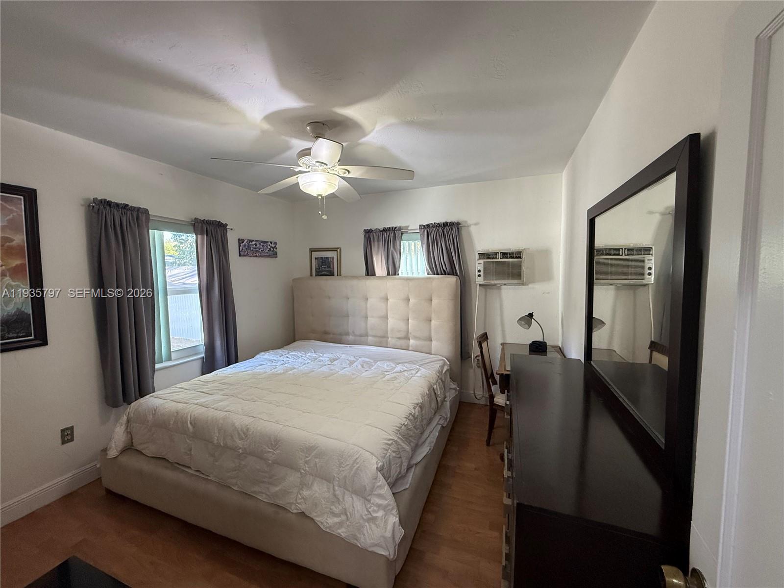 79 Northwest 143rd Street Miami, FL 33168 - Photo 11 of 37 a bedroom with a large bed and a chandelier