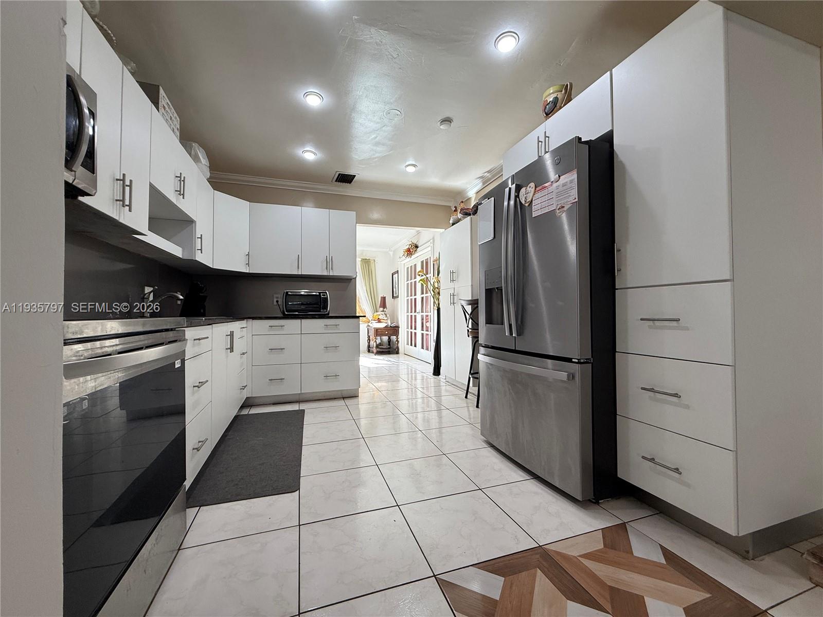 79 Northwest 143rd Street Miami, FL 33168 - Photo 16 of 37 a kitchen with granite countertop a refrigerator and a stove top oven