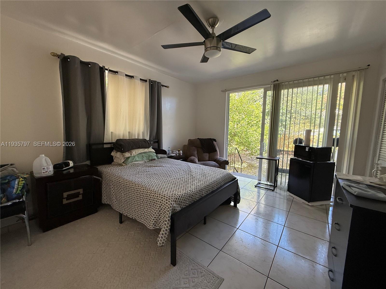 79 Northwest 143rd Street Miami, FL 33168 - Photo 22 of 37 a spacious bedroom with a bed and a chandelier