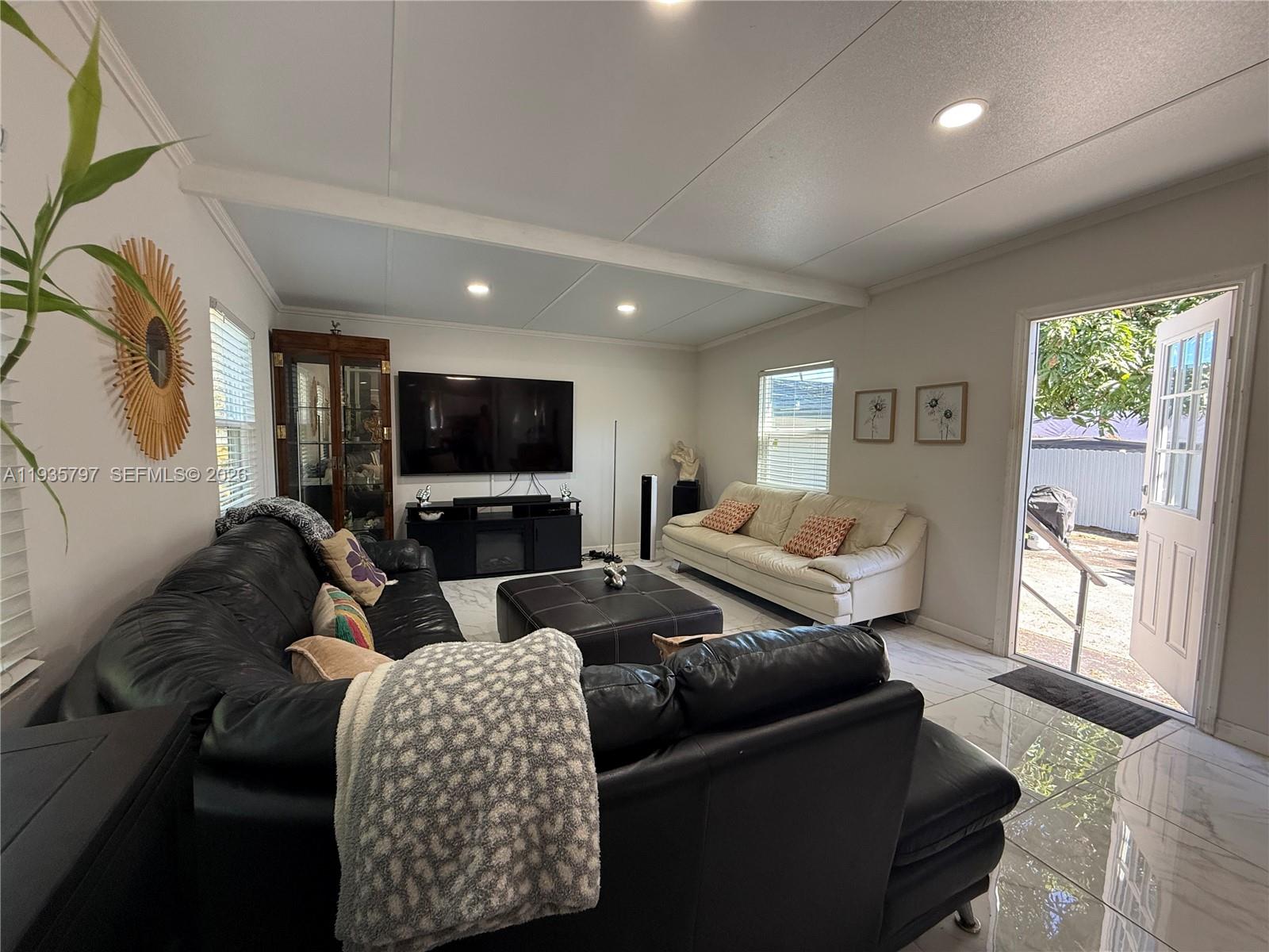 79 Northwest 143rd Street Miami, FL 33168 - Photo 27 of 37 a living room with furniture and a flat screen tv
