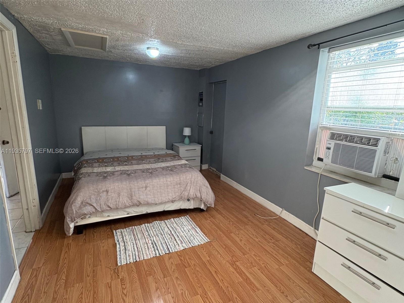 79 Northwest 143rd Street Miami, FL 33168 - Photo 33 of 37 a bedroom with a bed and wooden floor