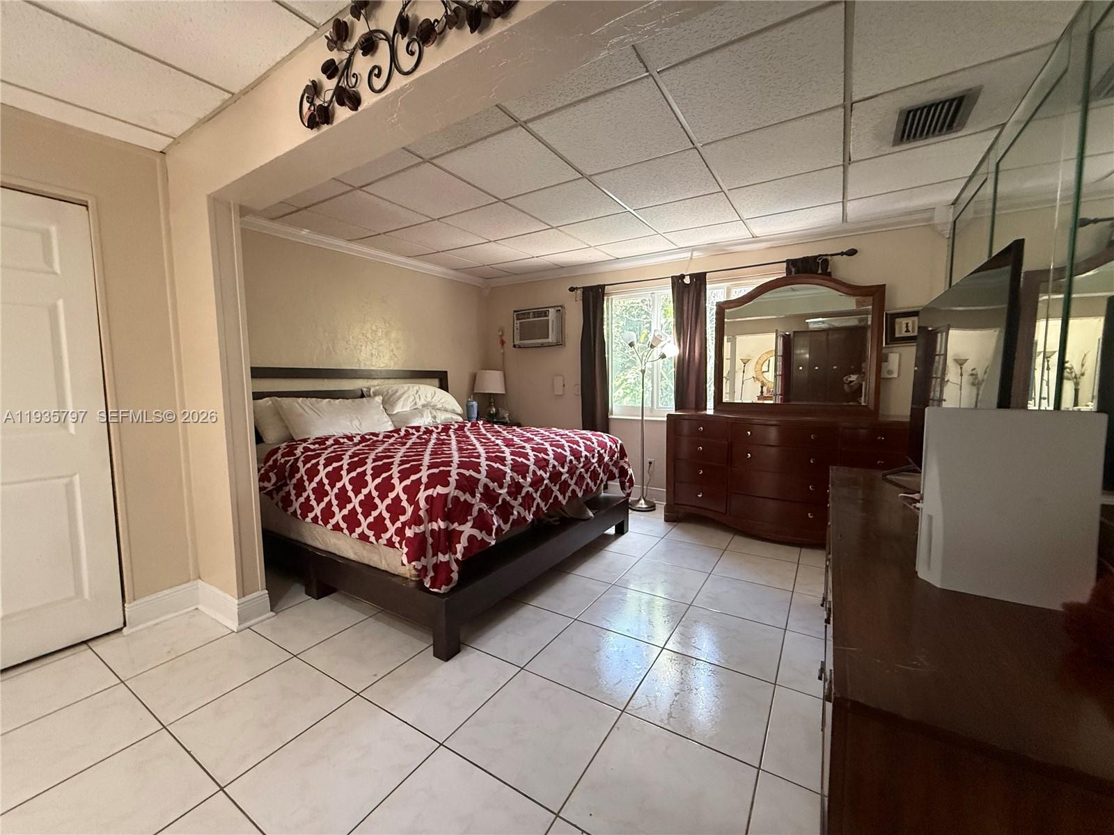 79 Northwest 143rd Street Miami, FL 33168 - Photo 6 of 37 a bedroom with a large bed and a chandelier