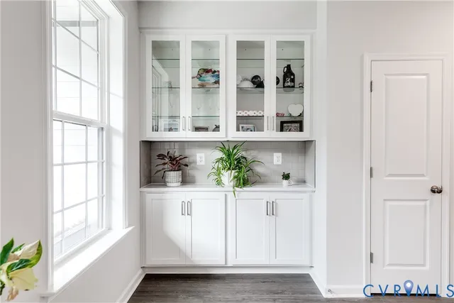 a view of an entryway with wooden floor and cabinet
