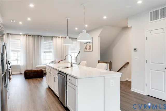 a kitchen with a sink a stove and a wooden floor