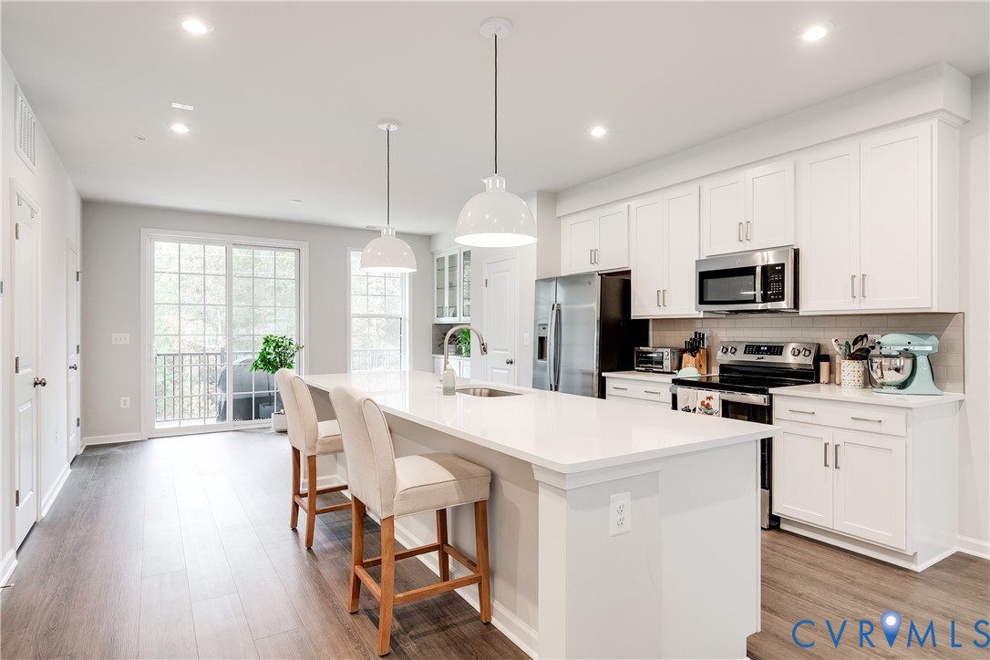 13267 Garland Lane Midlothian, VA 23114 - Photo 10 of 35 a kitchen with stainless steel appliances a stove a sink a microwave a refrigerator a dining table and chairs