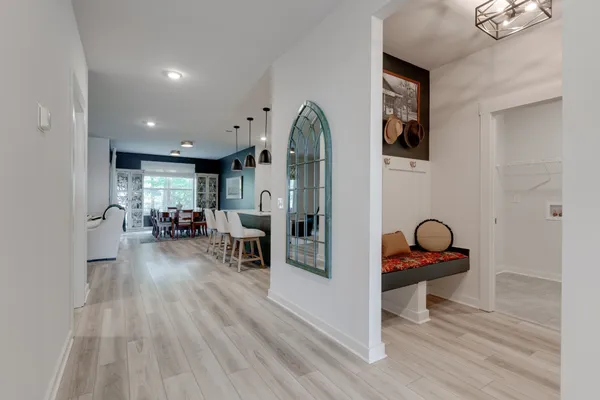 a kitchen with stainless steel appliances kitchen island granite countertop a stove a refrigerator a kitchen island a dining table and chairs with wooden floor