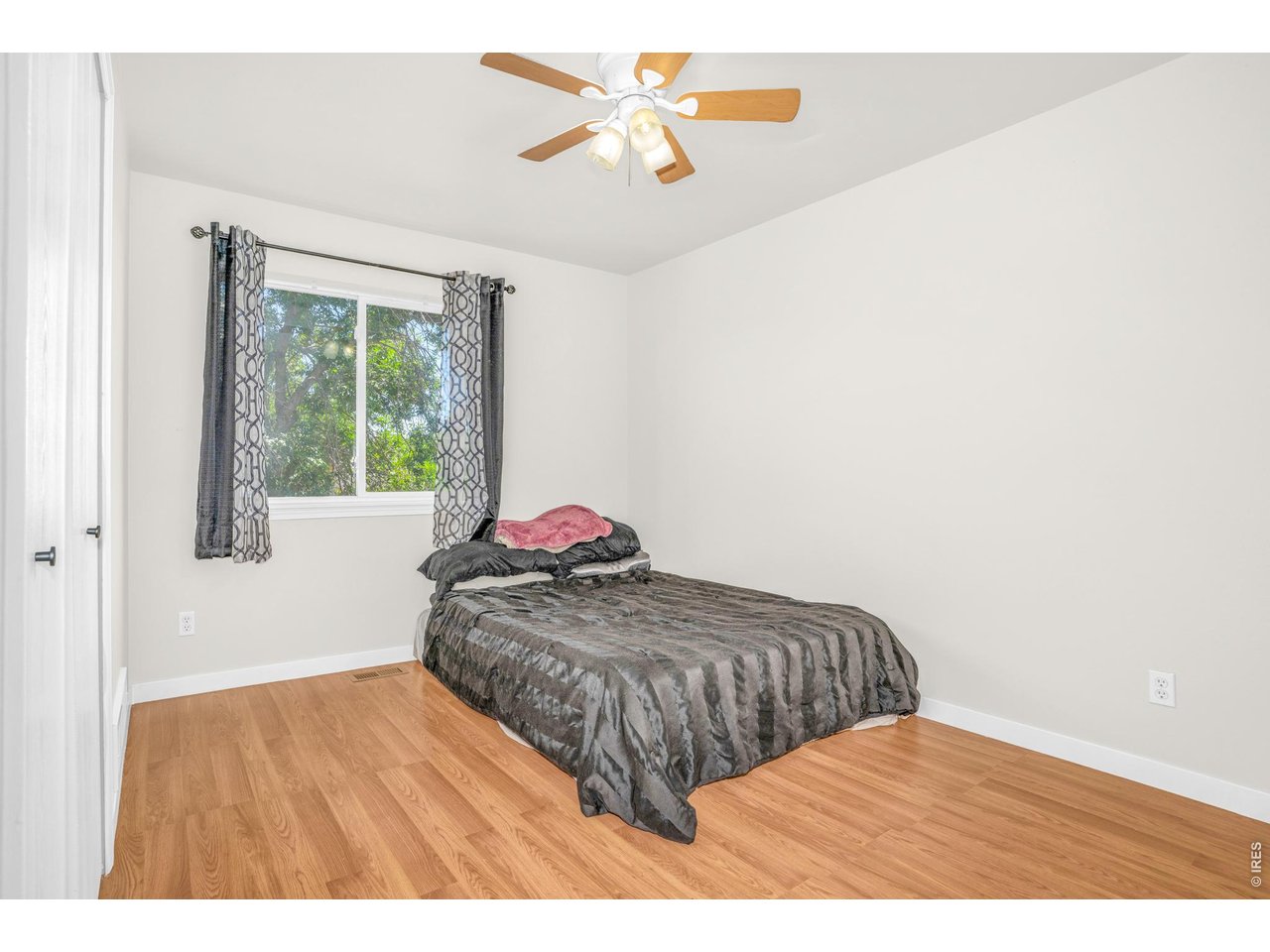 526 East 23rd Street Road Greeley, CO 80631 - Photo 13 of 20 a bedroom with a bed and a chandelier fan