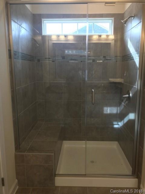 1573 Tranquility Boulevard, Unit 427 Lancaster, SC 29720 - Photo 5 of 12 a bathroom with a glass shower door