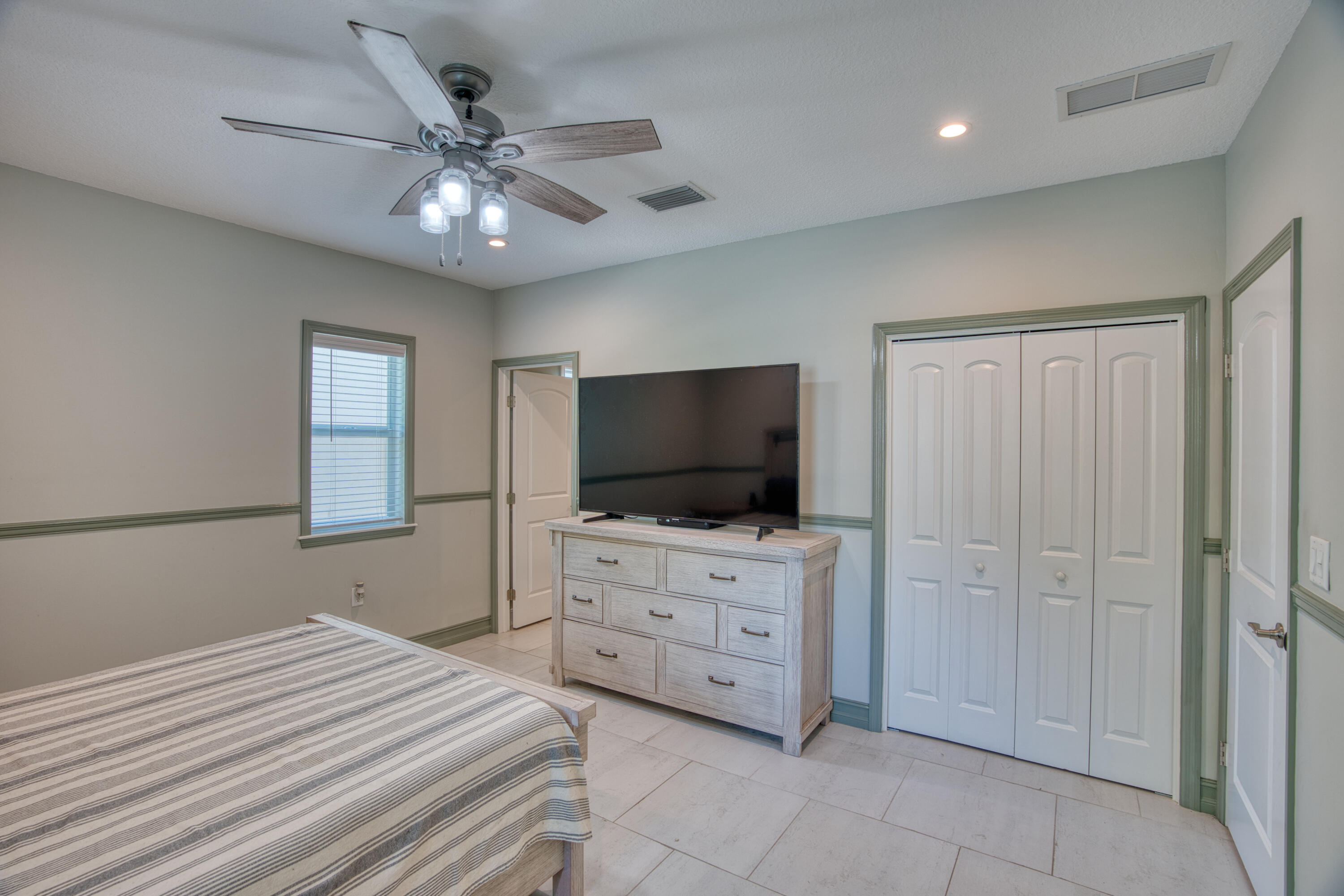 499 Beach Road Tavernier, FL 33070 - Photo 20 of 53 a bedroom with a bed and a flat tv screen on dresser