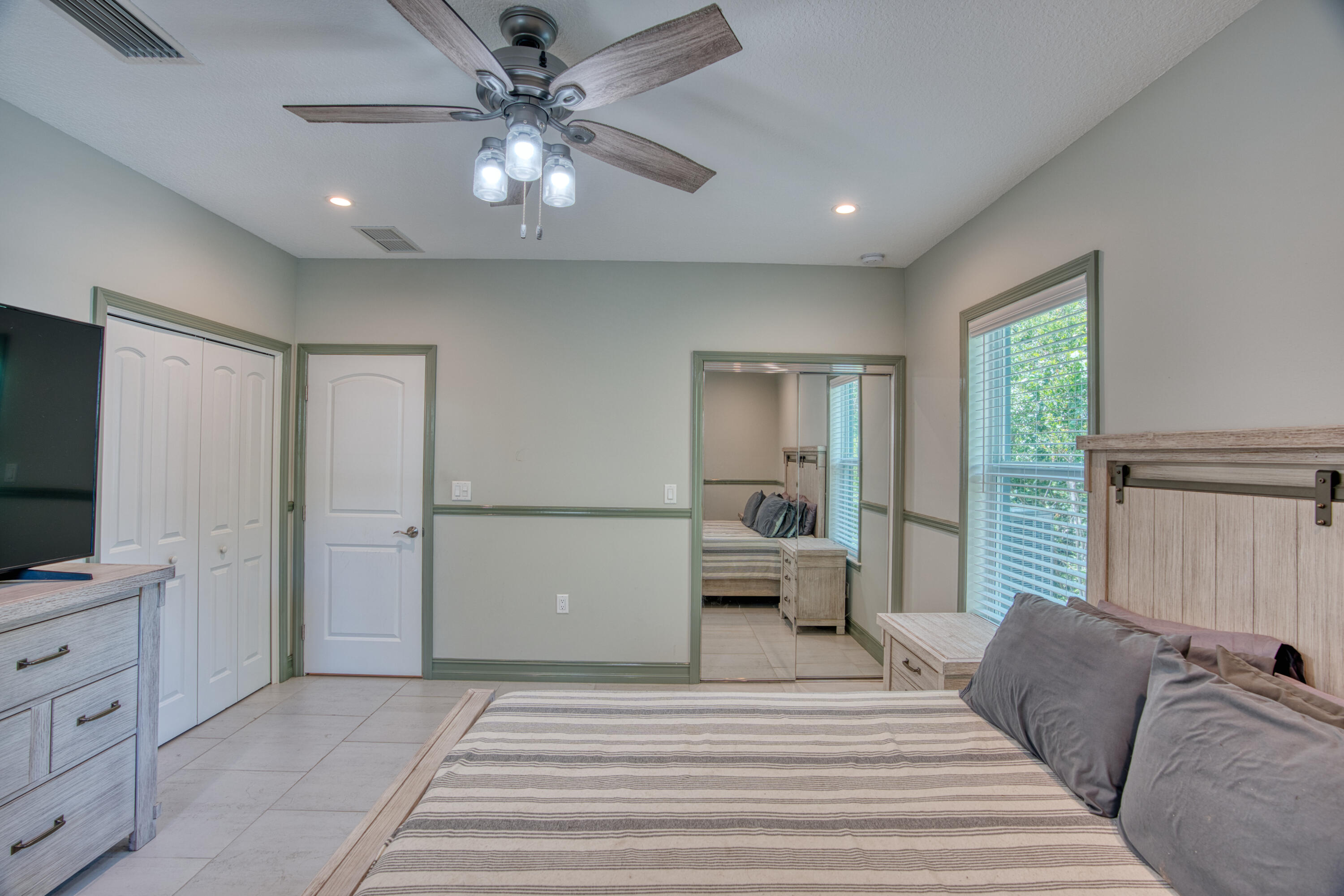 499 Beach Road Tavernier, FL 33070 - Photo 21 of 53 a bedroom with a large bed and a chandelier