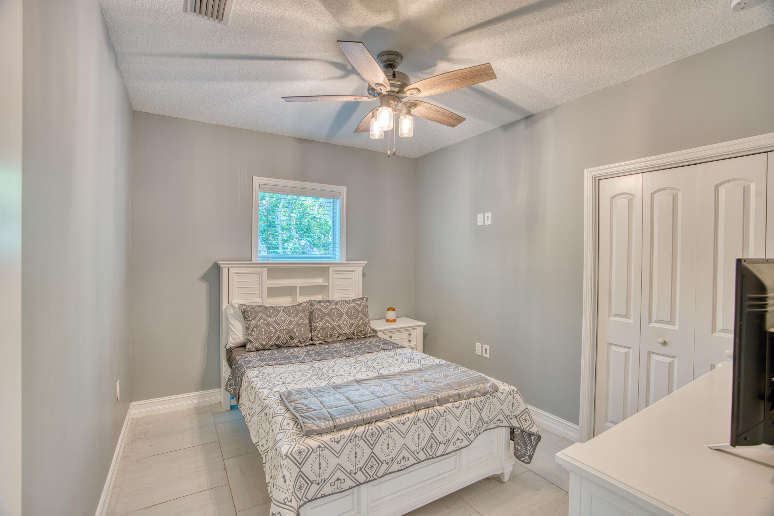 499 Beach Road Tavernier, FL 33070 - Photo 25 of 53 a bedroom with a bed and a chandelier
