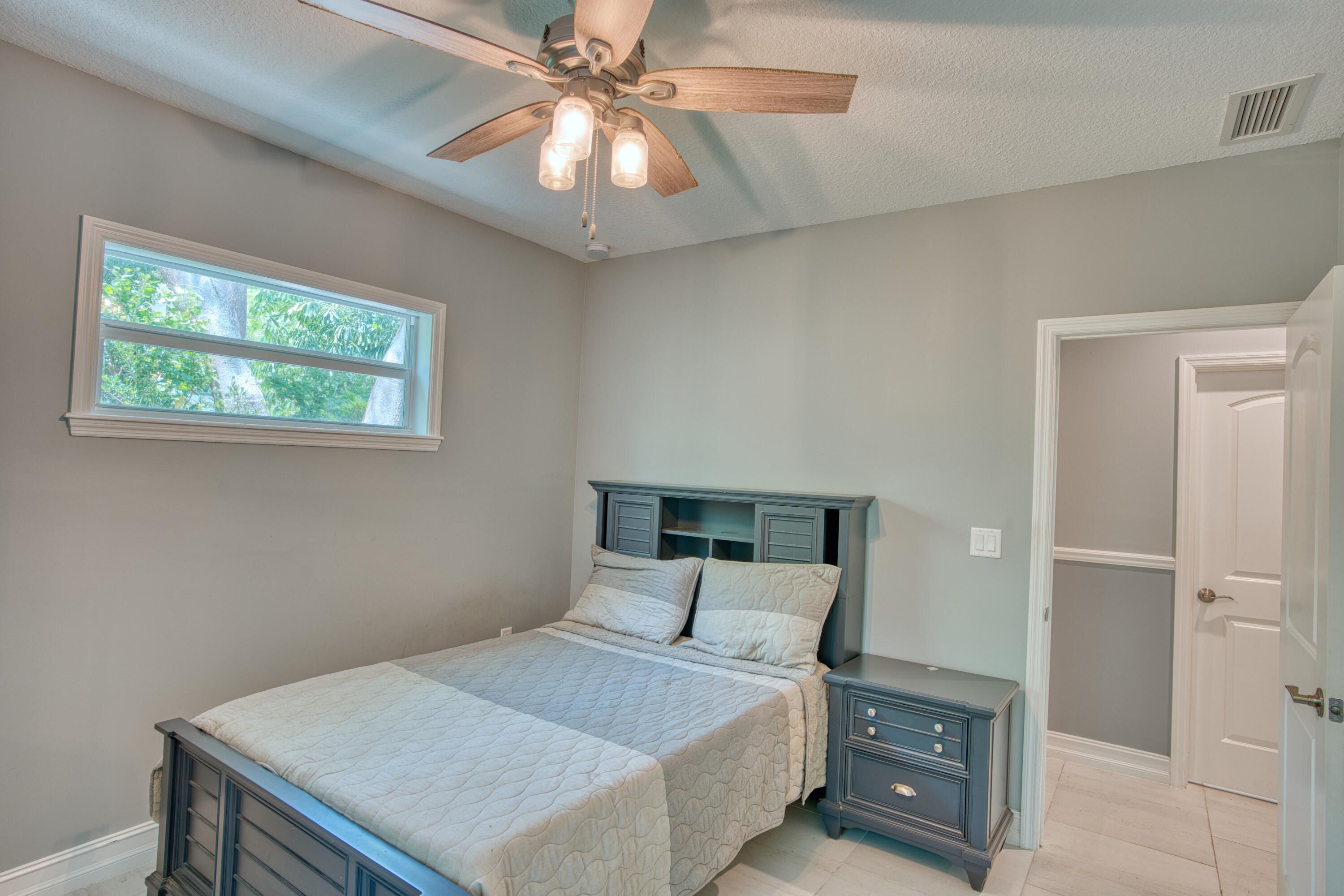 499 Beach Road Tavernier, FL 33070 - Photo 30 of 53 a bedroom with a bed and a chandelier