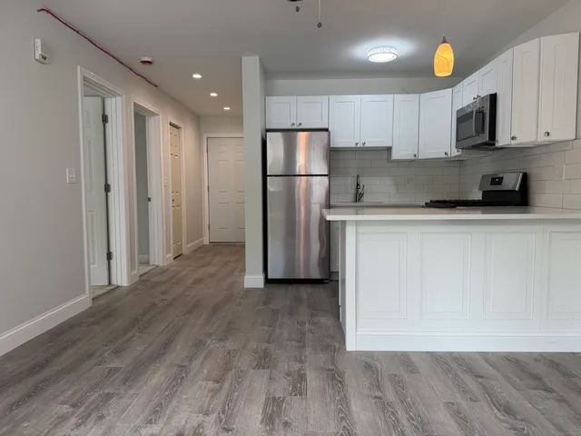 a kitchen with stainless steel appliances granite countertop a refrigerator a stove top oven a sink and cabinets