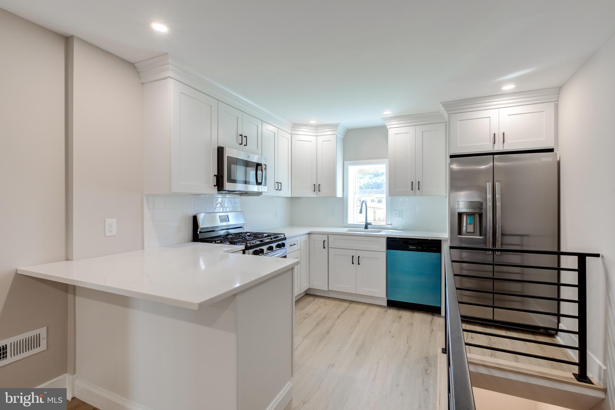 a kitchen with a refrigerator and a stove top oven