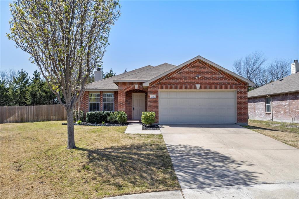 Ranch-style house featuring concrete driveway, fence, an attached garage, a front lawn, and brick siding