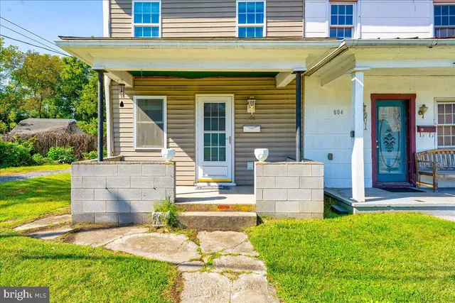 a front view of a house with a garden and plants