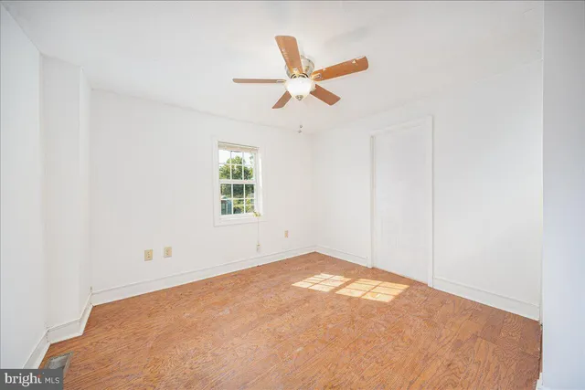 an empty room with closet and windows