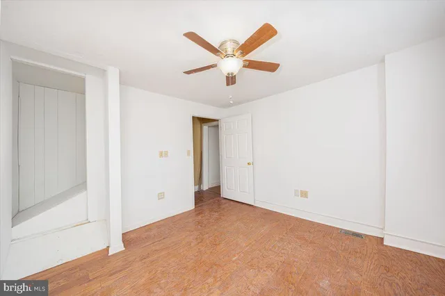 an empty room with closet and ceiling fan