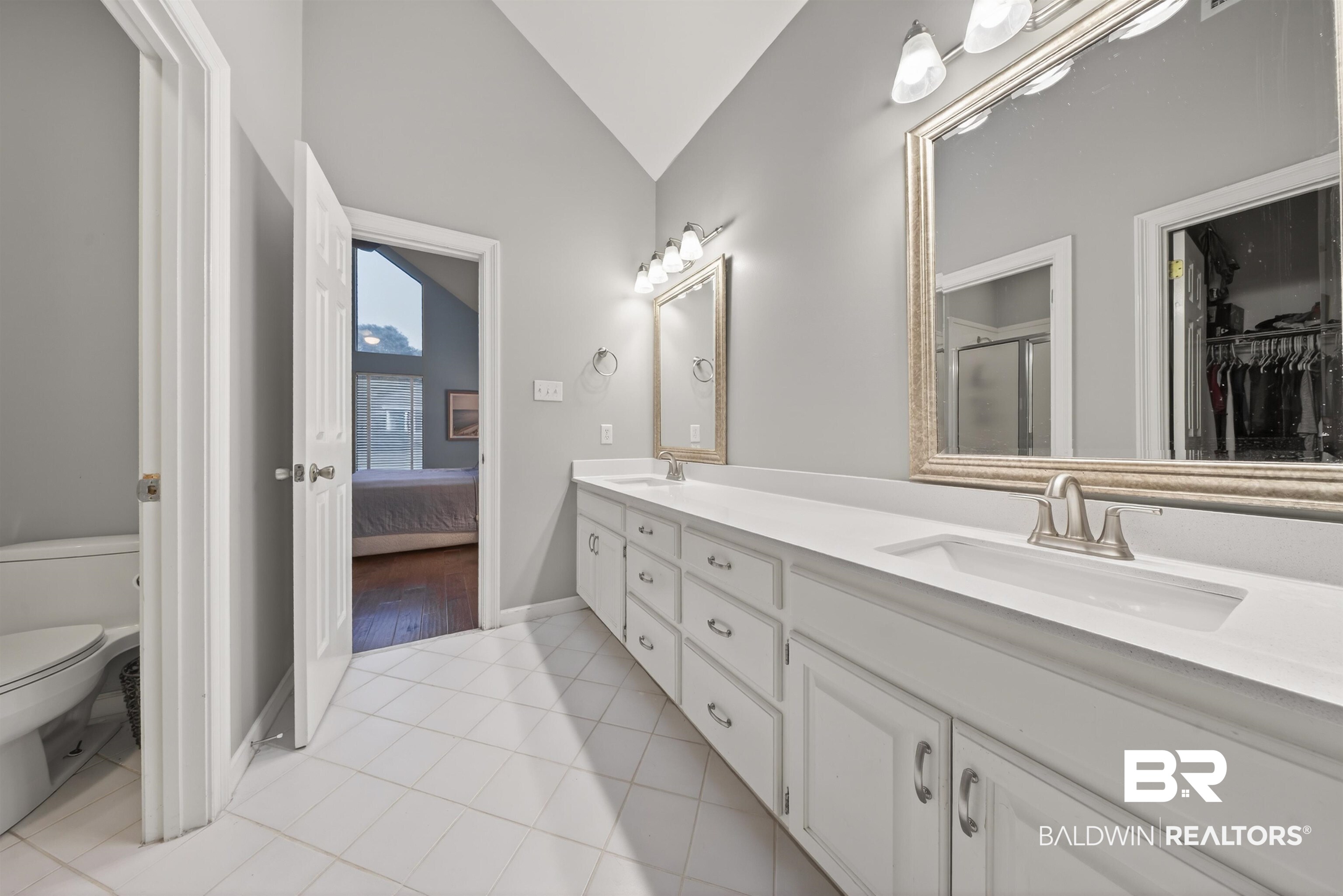 1250 Savannah Drive Mobile, AL 36609 - Photo 27 of 35 Full bathroom featuring vaulted ceiling, double vanity, ensuite bath, light tile patterned floors, and a walk in closet