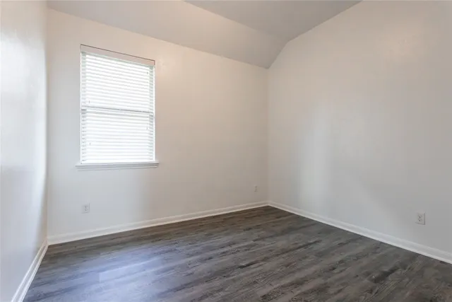 an empty room with wooden floor and a window