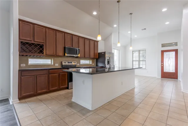 a kitchen with stainless steel appliances granite countertop a refrigerator a sink dishwasher and a oven