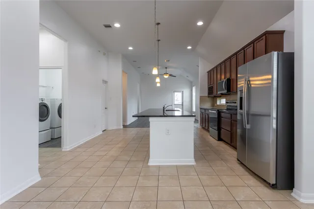 a kitchen with stainless steel appliances a refrigerator sink and cabinets