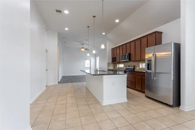 a kitchen with stainless steel appliances granite countertop a refrigerator and a sink