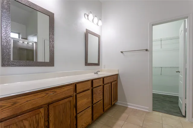 a bathroom with a double vanity sink mirror and shower