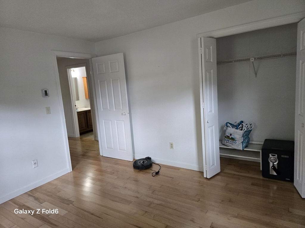 222 Buck Island Road, Unit 45 Yarmouth, MA 02673 - Photo 18 of 23 a view of an empty room with wooden floor and a window