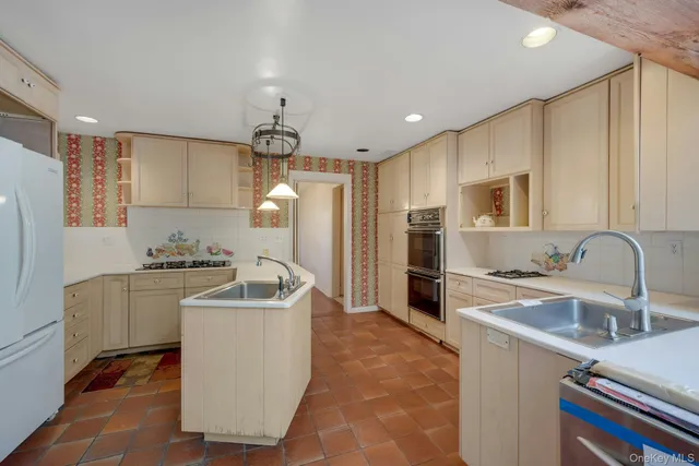 a kitchen with kitchen island a sink stove and refrigerator