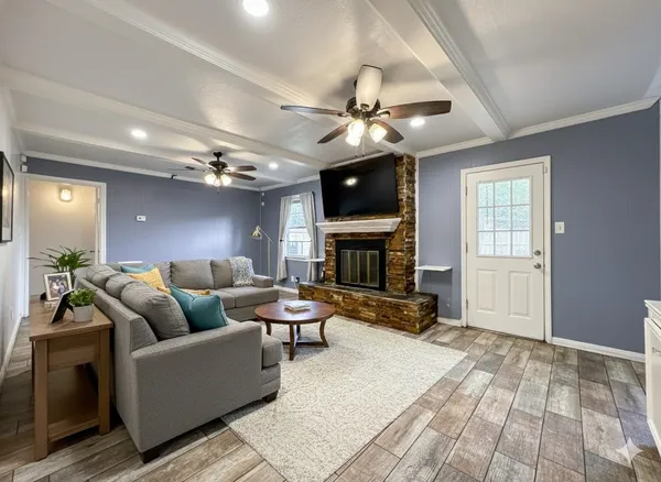 a living room with furniture a fireplace and a flat screen tv