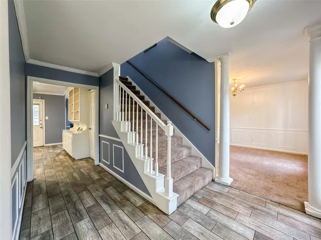 a view of a hallway with wooden floor and staircase