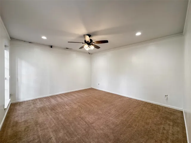 a view of a livingroom with a ceiling fan and carpet