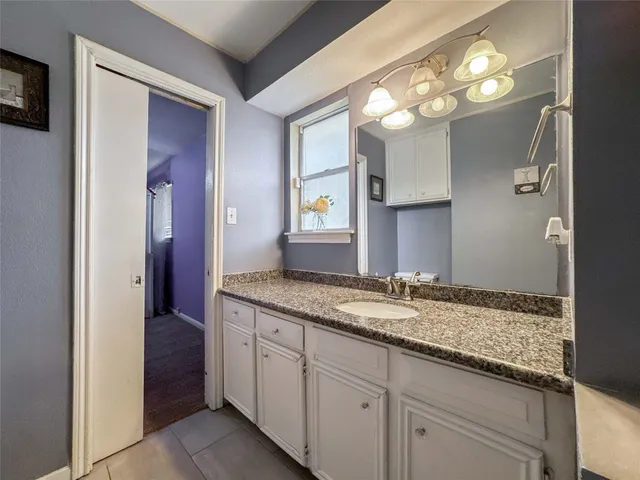 a bathroom with a granite countertop sink and a mirror